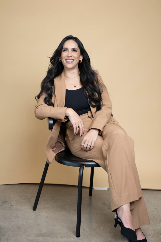 woman in tan and black suit laughing who is wanting to move up in her small company