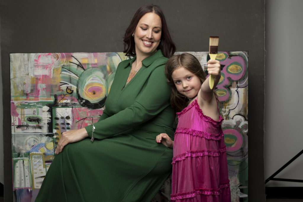 mother with daughter holding a paintbrush