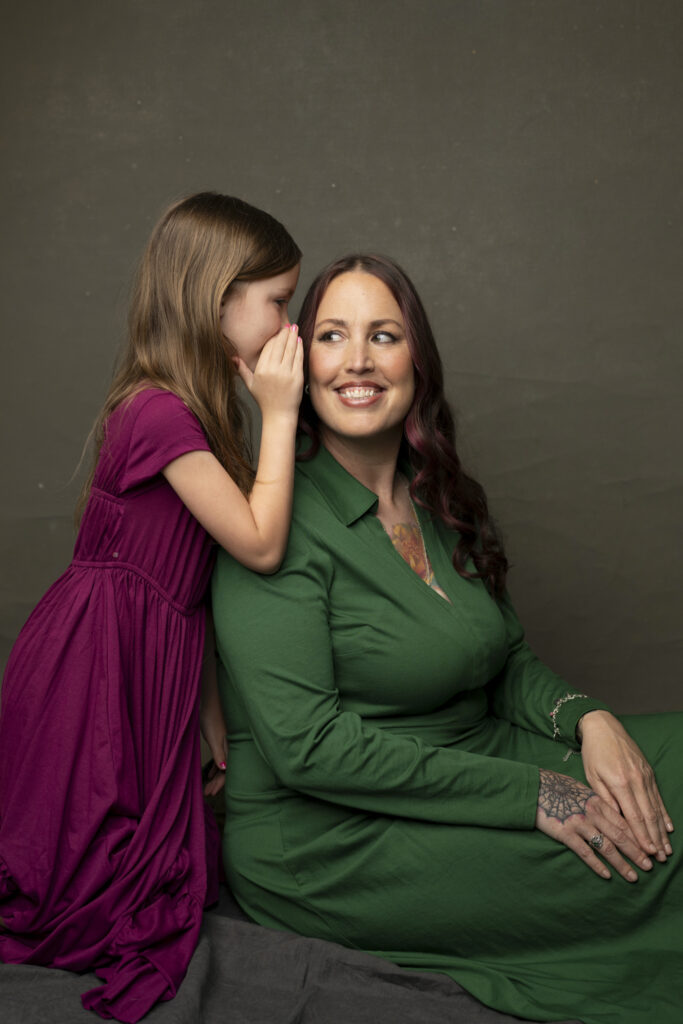 girl whispering in her mother's ear for their mother-daughter photos