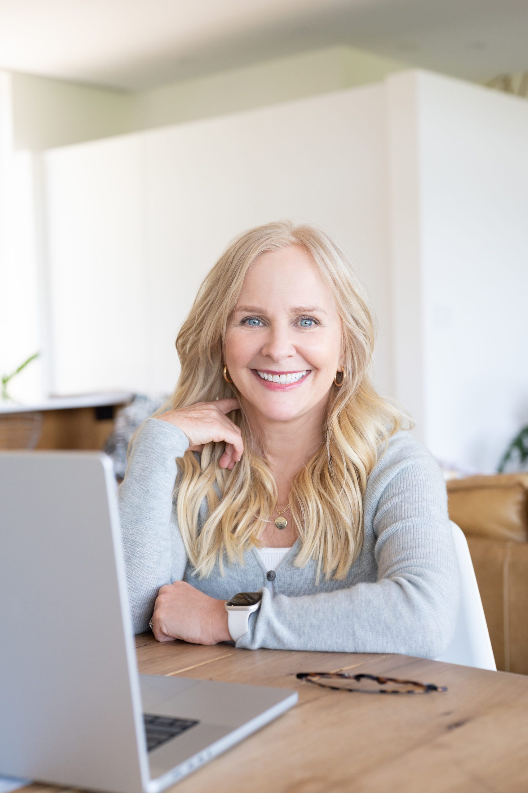 woman business owner sitting at laptop smiling